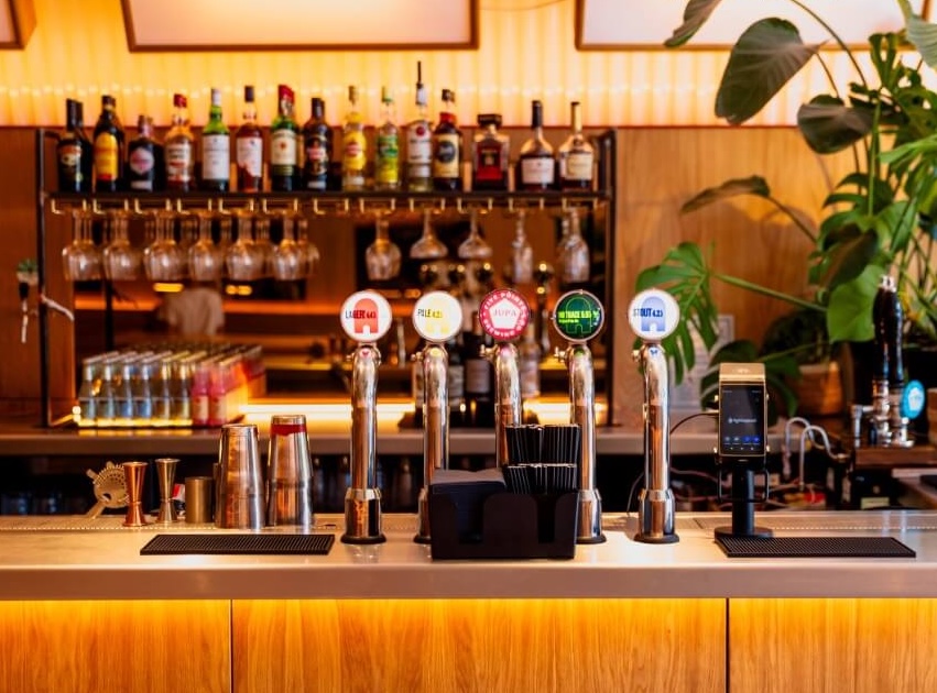 Beer taps on a stainless steel bar selling Bird House beer