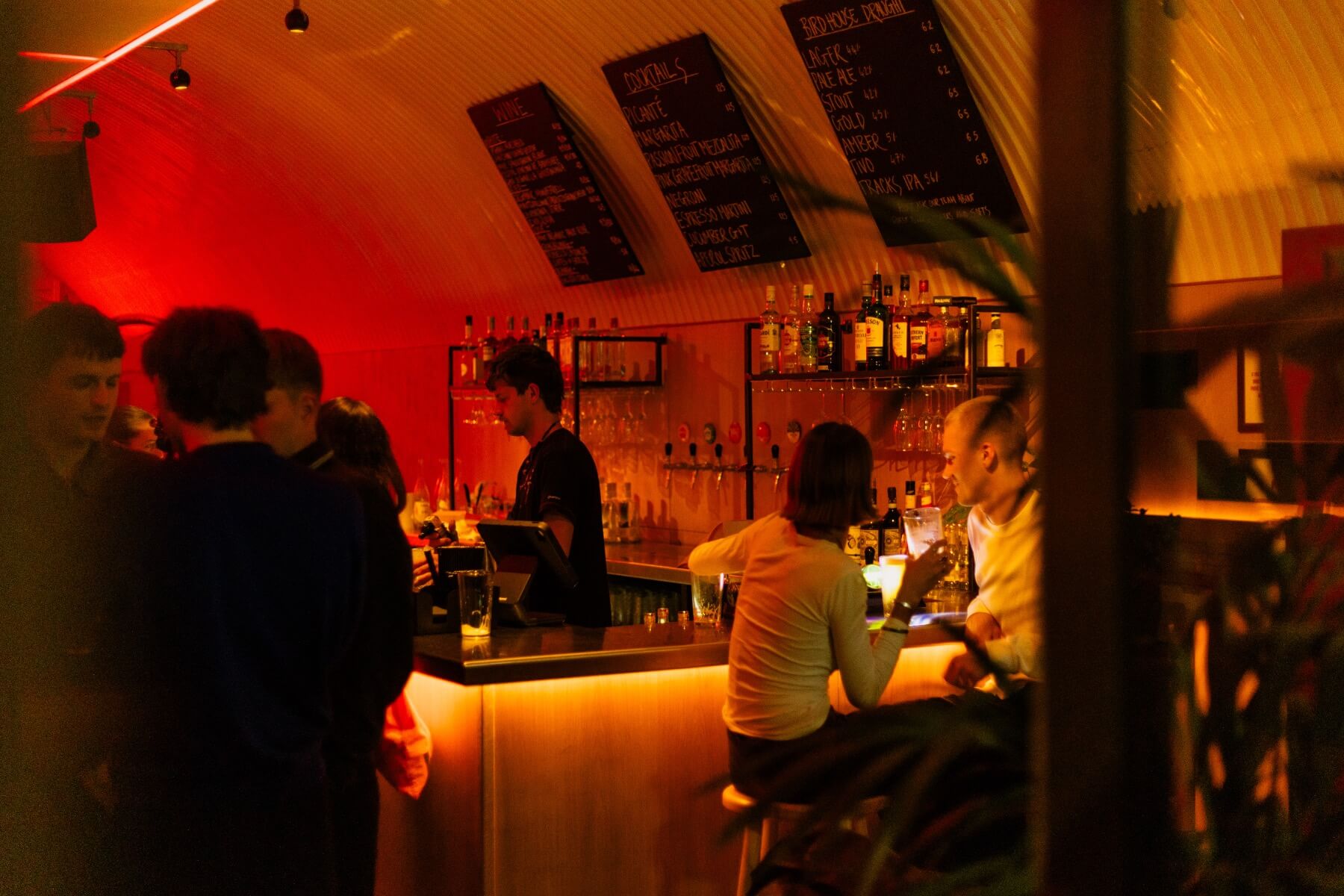 People chatting by an atmospheric bar