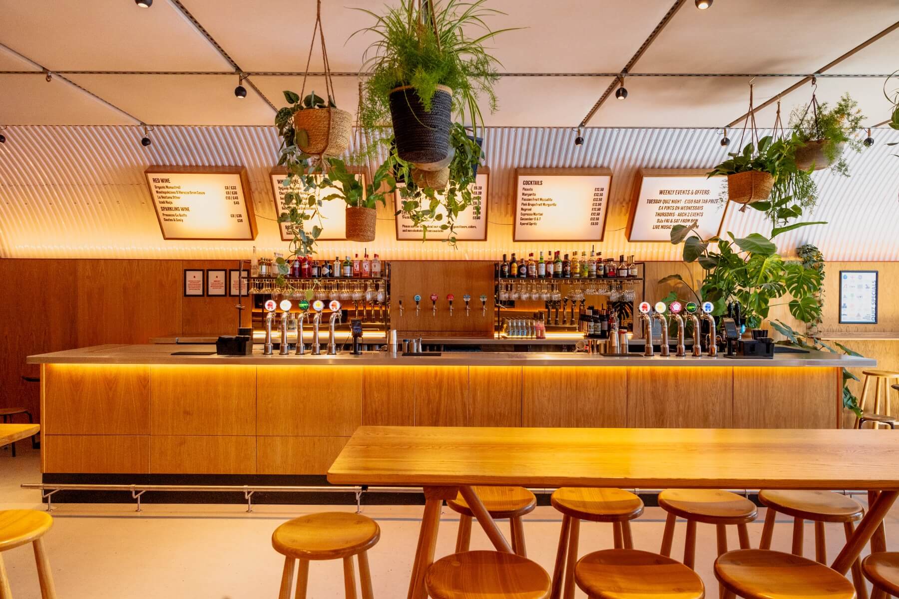 Taproom bar with high seating and lit up menus