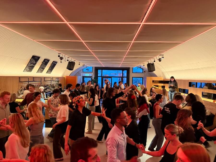 Salsa dancers dancing in a well lit red room