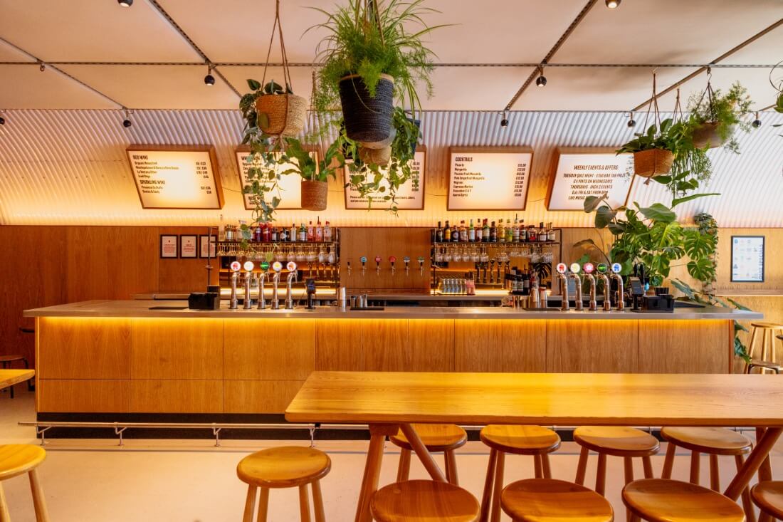 Taproom bar with high seating and lit up menus