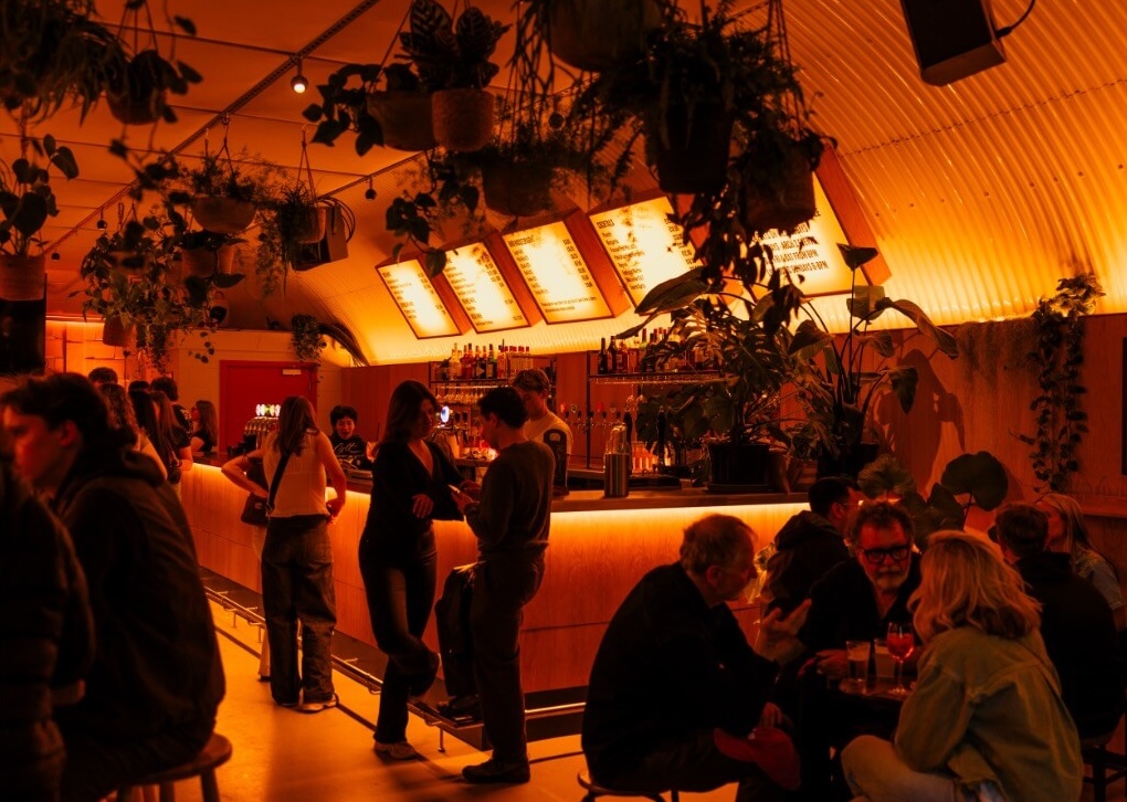 People drinking in the taproom under atmospheric lighting