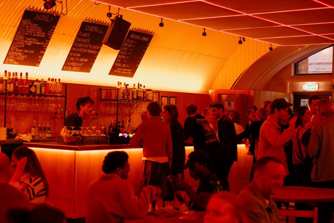 People buying drinks in a well lit bar